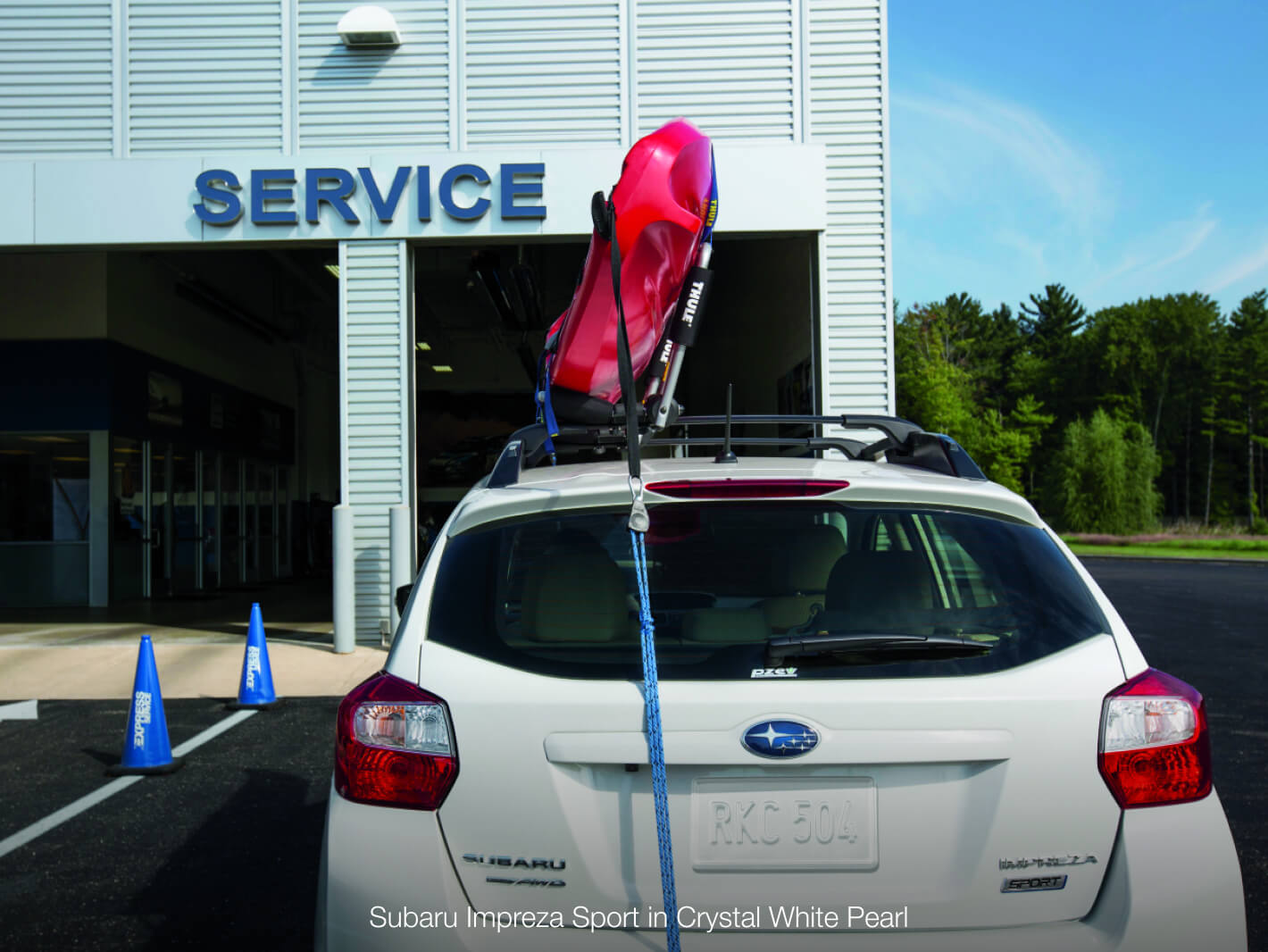 Subaru Impreza Sport in Crystal White Pearl parked outside of the Subaru Service Center