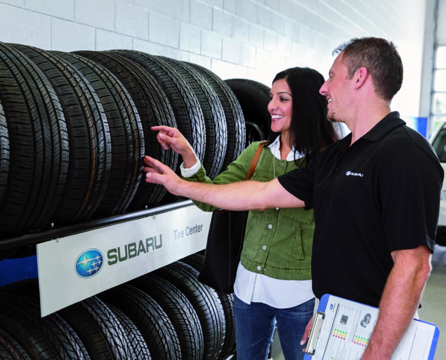 Subaru Service Technician assisting customer in choosing the right tires for her vehicle