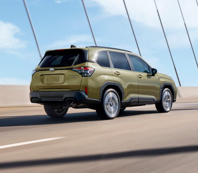 Subaru Forester Hybrid drives on a sunny bridge.
