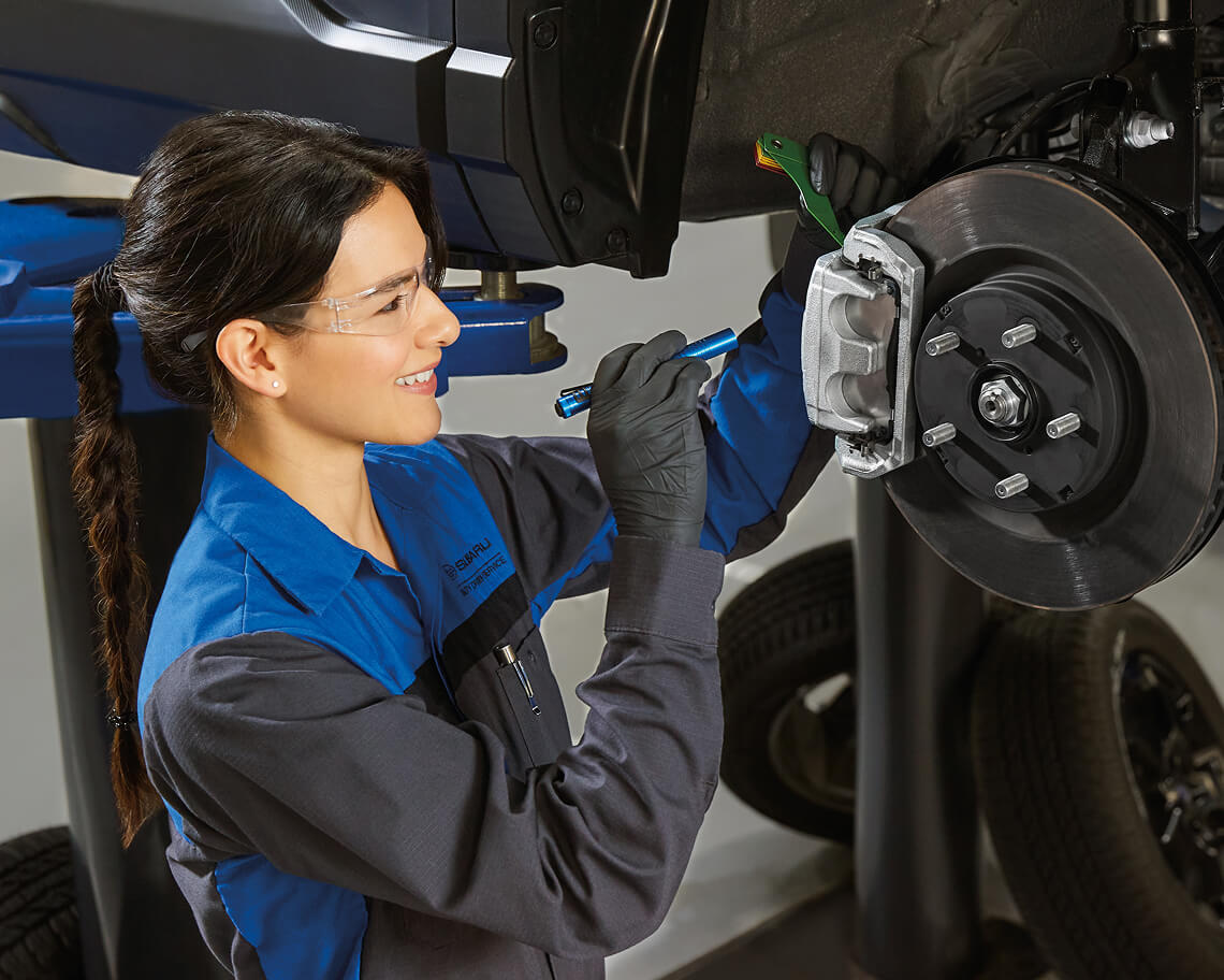 Subaru certified technician performing a brake inspection